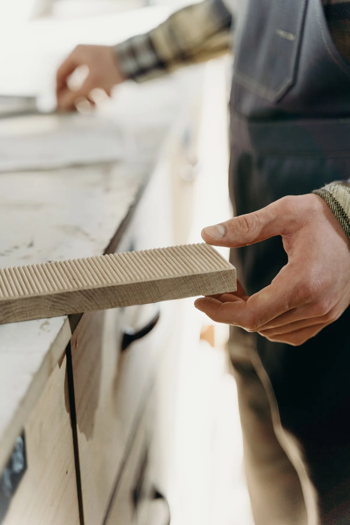 Craftsperson shaping timber at a workbench
